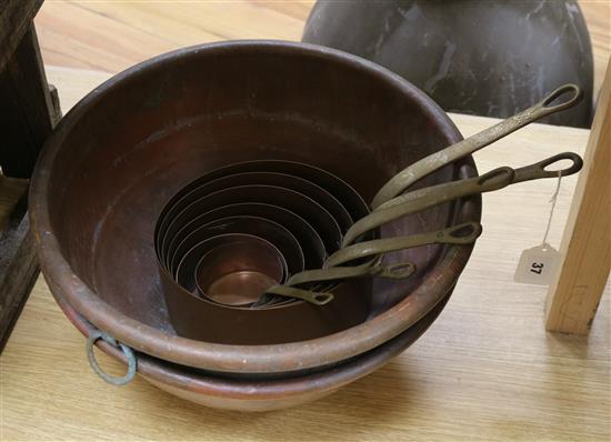 Two circular copper pans and brass saucepans